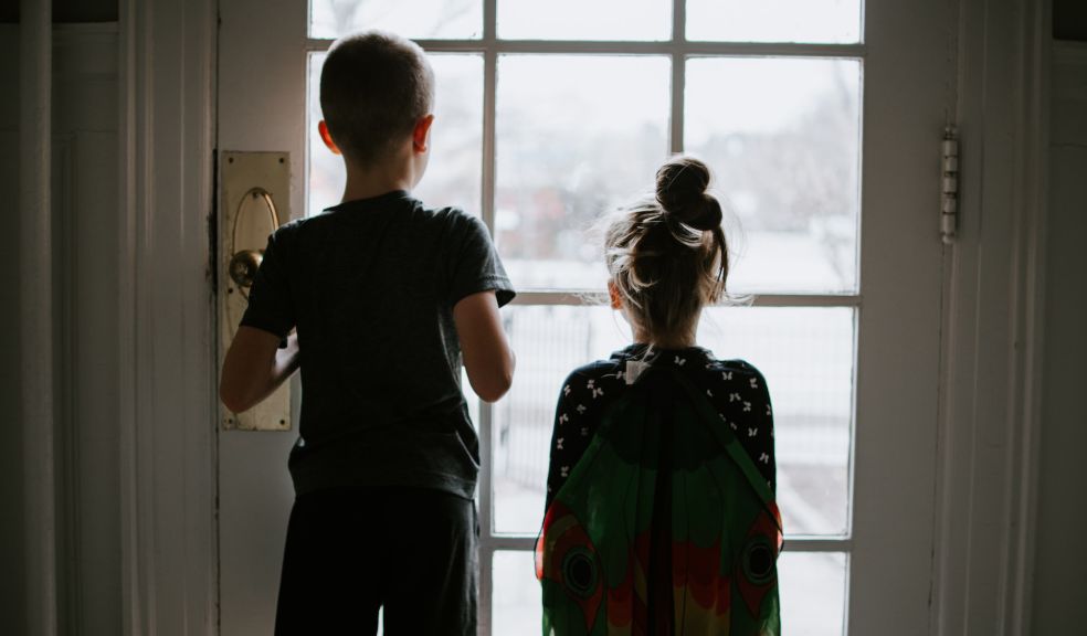 children stuck indoors, looking out of the window
