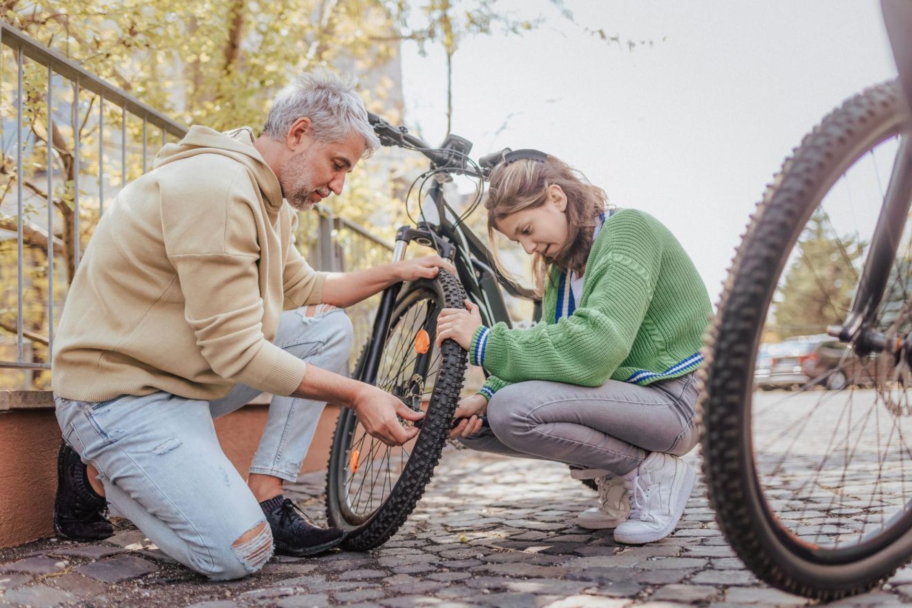 Teenager fixing bicycle while learning practical life skills